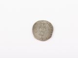 a silver coin on a white surface with a white background