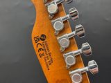 the headstock of an electric guitar with a wooden neck