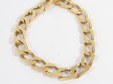 a close up of a gold chain bracelet on a white surface