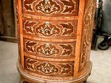 a wooden chest of drawers in a room with a stair case