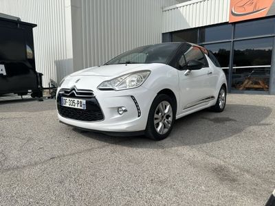the small white car is parked in front of a building