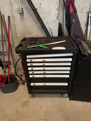 a black tool box with tools on it in a garage