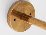 a wooden stick sticking out of a brass wall hook