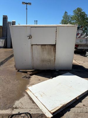 un réfrigérateur blanc posé au milieu d'un parking