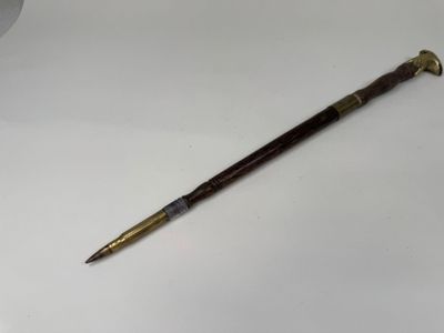 un vieux stylo posé sur une table blanche, à côté d'une tasse