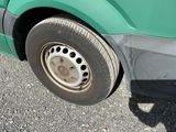a close up of a tire on a green bus
