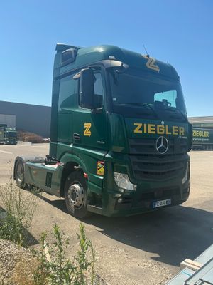 a green truck that is parked in a parking lot