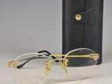 pair of gold rimmed glasses next to a black case on a table