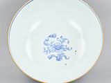 a blue and white bowl with a flower design on the rim