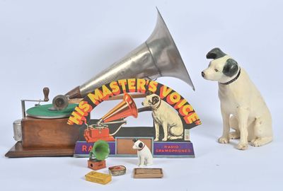un chien assis à côté d'un gramophone et d'autres objets