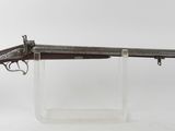 un vieux pistolet avec un canon en bois et un support en verre