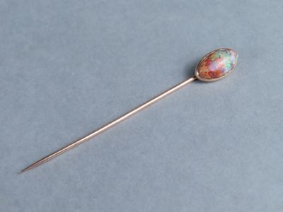 un gros plan d'un bâton en métal orné d'une pierre colorée