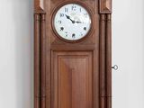 a wooden clock hanging on the wall in a room
