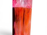 pink and red crystal on a white surface with a white background