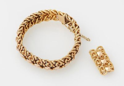 a close up of a bracelet and a ring on a white surface