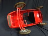 a red toy car that is sitting on a black background