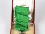 une médaille dans un écrin rouge contenant un ruban vert
