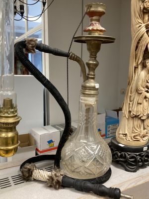 a glass vase with a hook on top of a counter