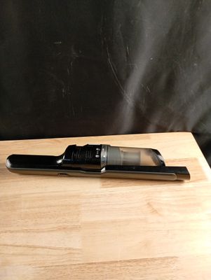 un sèche-cheveux posé sur une table en bois à côté d'un téléphone portable
