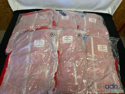 six sacs de chemises roses emballés dans du plastique, posés sur une table