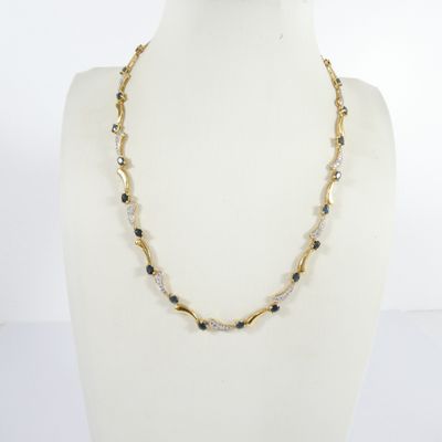 un collier de perles dorées et noires sur un mannequin