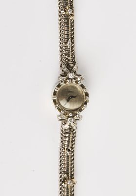 un gros plan d'une montre sur une surface blanche avec un fond blanc