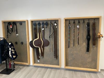 une exposition de harnais et de rênes accrochés au mur