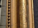 a close up of a gold frame with a picture on it