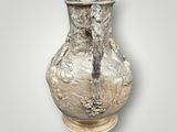 a silver vase that is sitting on a table