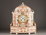 a white and orange clock sitting on a table