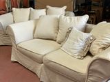 a white couch with many pillows on it in a room