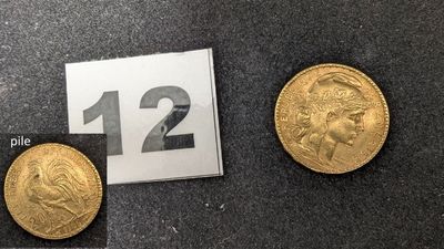 Trois types différents de pièces d'or sont exposés sur un fond noir