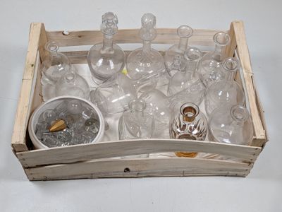 bottles and glasses in a wooden box on a white surface