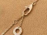 a close up of a gold chain with a coin on it