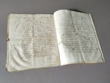 an old book with writing on it sitting on a table