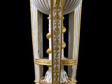 un vase doré et blanc orné d'un rideau