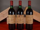 three bottles of wine sitting on top of a table next to a wooden box