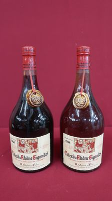 two bottles of wine sitting next to each other on a red surface