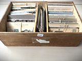 une caisse en bois remplie de livres posée sur une table blanche