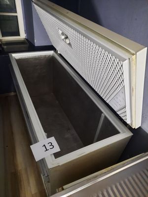 a large open refrigerator sitting on a wooden floor in a room