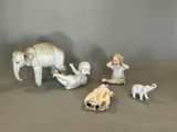 trois figurines représentant des enfants et un éléphant posées sur une table