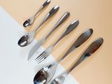 five forks and spoons arranged in a row on top of a table