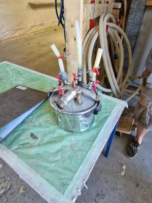 une petite table sur laquelle se trouve une casserole en métal, dans un garage