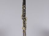 a close up of a clarinet on a clear surface with a gray background