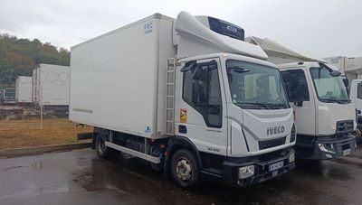 two trucks parked in a parking lot on a rainy day