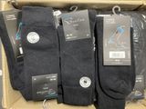 trois paires de chaussettes noires dans une boîte, avec leurs étiquettes
