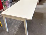 a white table with a yellow chair next to it