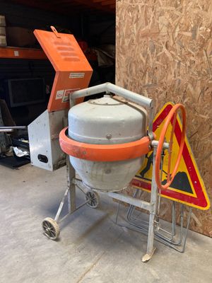 une bétonnière garée dans un garage, à côté d'un panneau de chantier