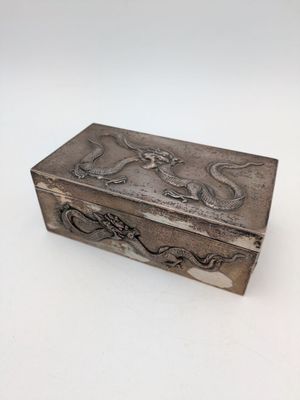 une boîte ancienne en argent ornée d'un motif de dragon sur le couvercle