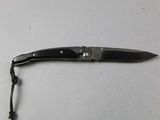 a small knife with a black handle on a white table